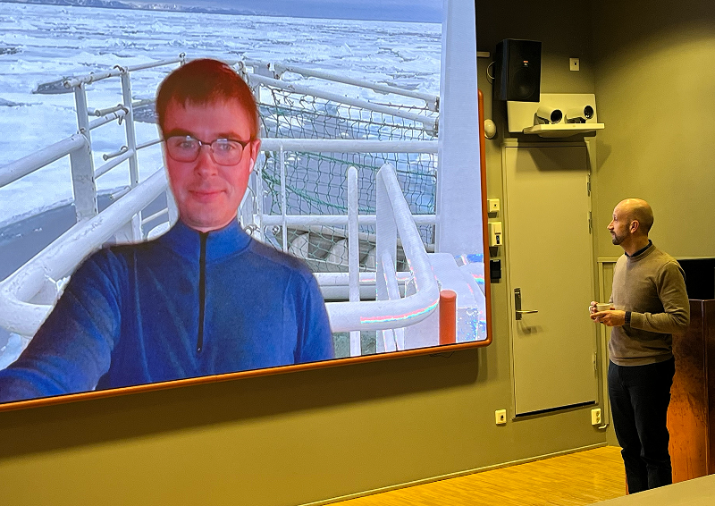 A person standing before a projector screen.